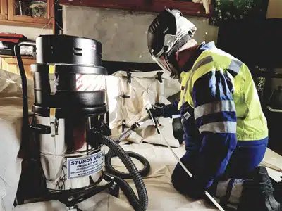 Chimney sweep at work with professional equipment