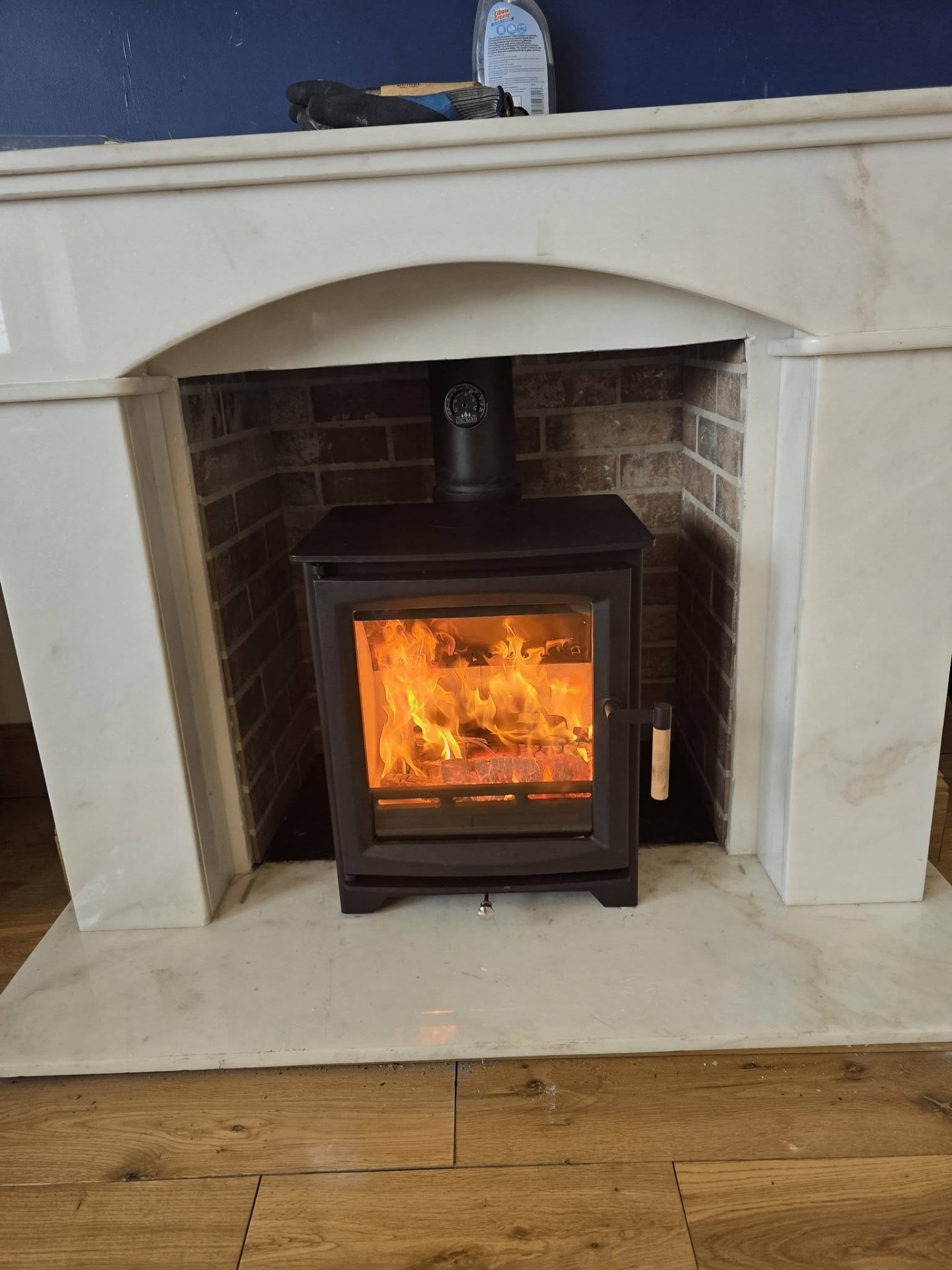 Inset stove installation in white marble fireplace