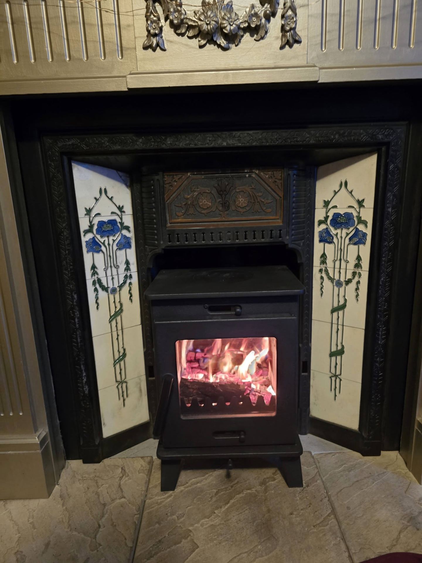 Traditional stove in decorative tiled cast iron surround