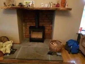 Woodburning stove installation in brick fireplace