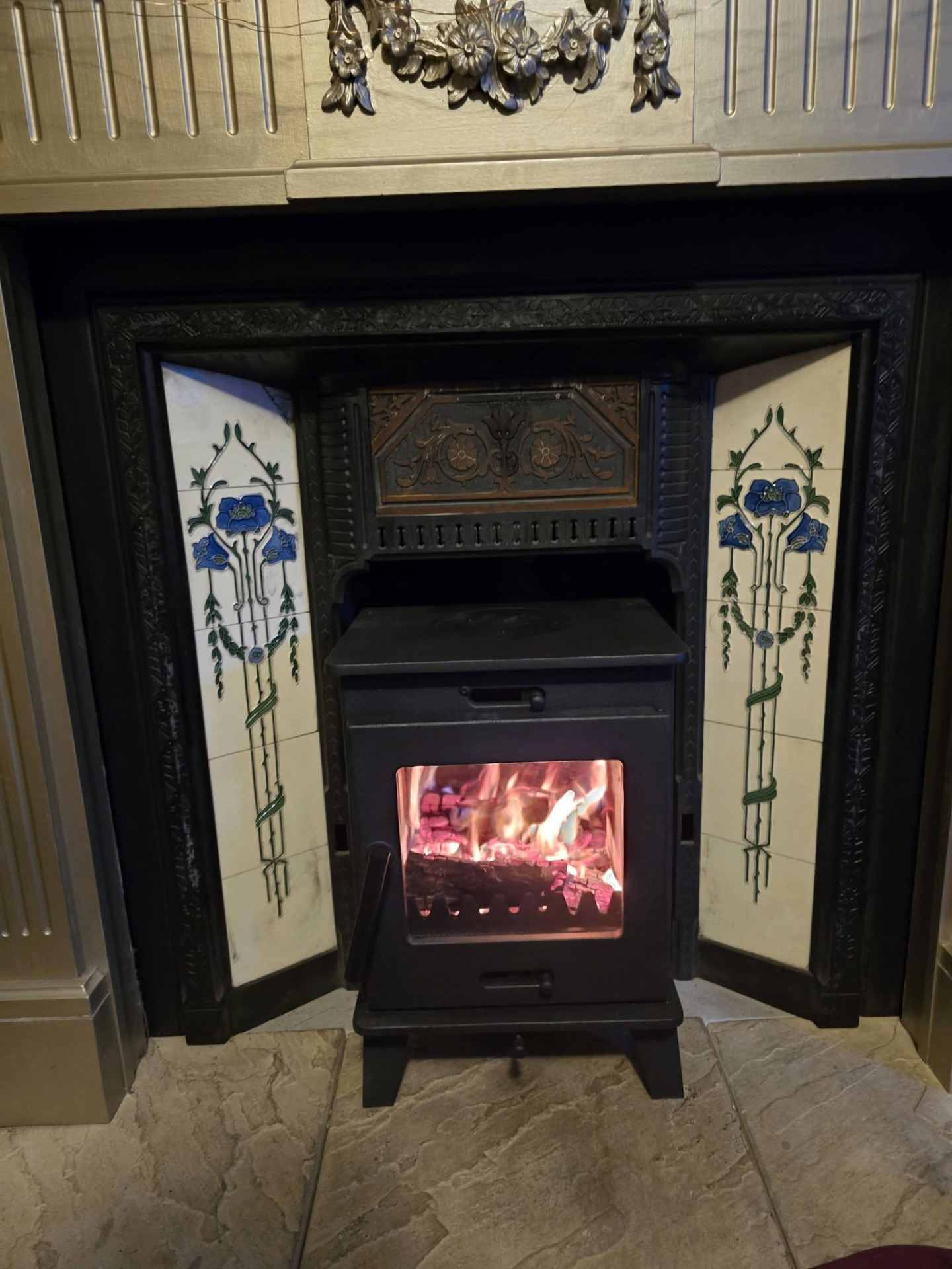 Multifuel stove in ornate Victorian tiled fireplace